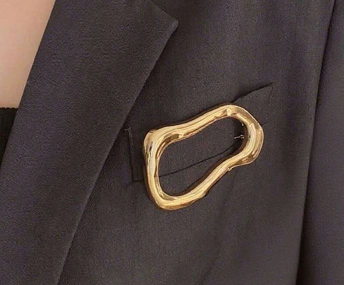 Gylden broche i asymmetrisk design