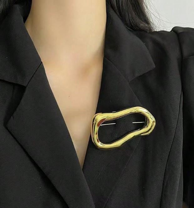 Gylden broche i asymmetrisk design